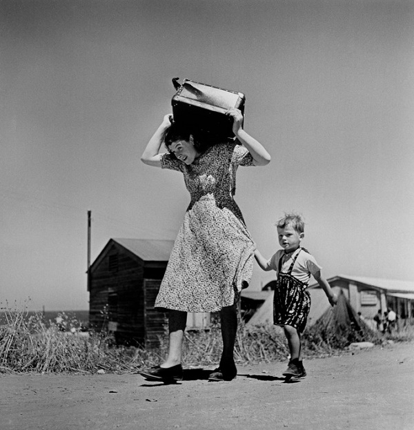 Robert Capa, Haifa. 1949-50. Woman carrying luggage accompanied by a small boy.